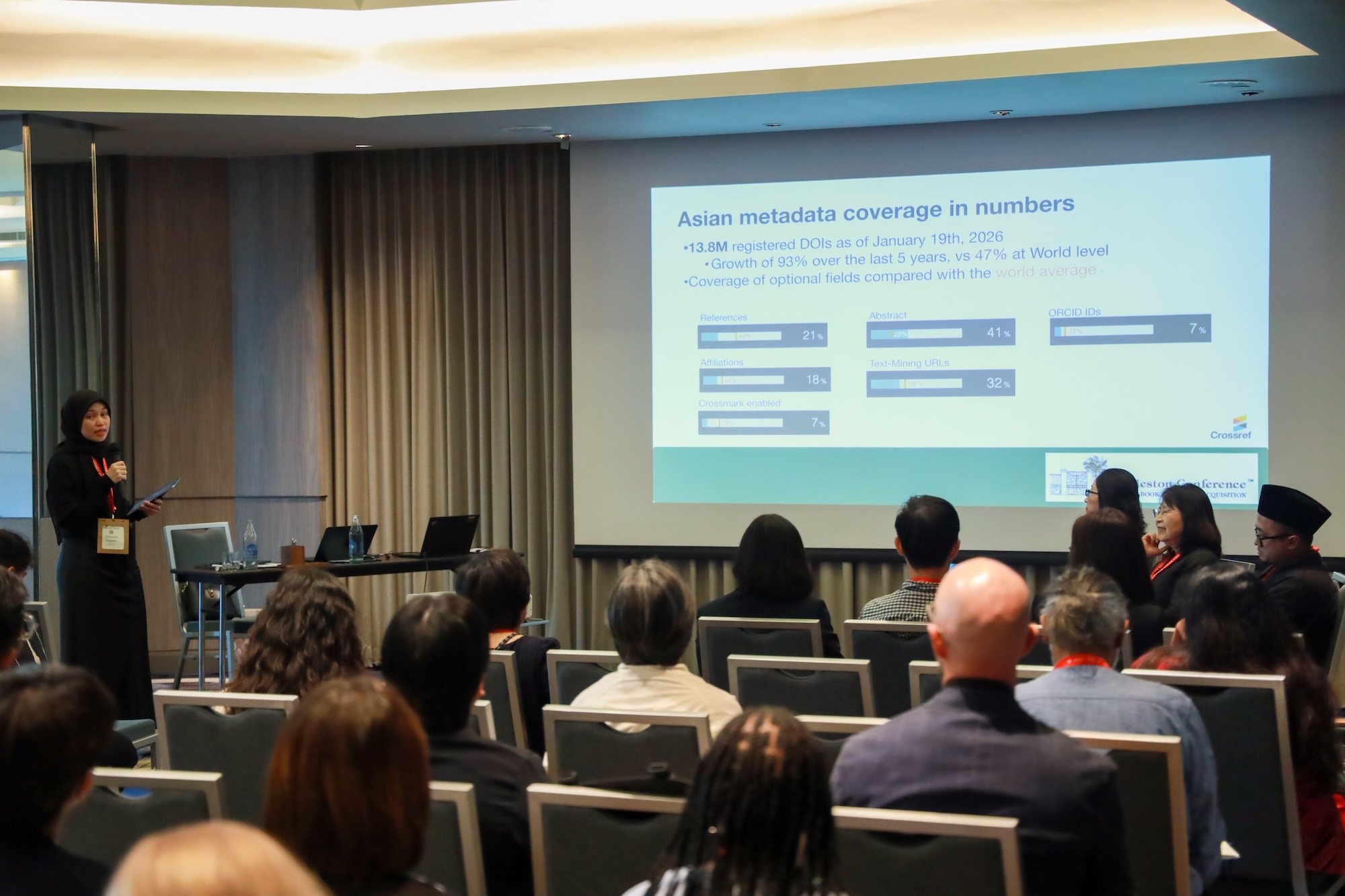 Robbykha presenting a slide to the audience that shows Asian metadata coverage in numbers